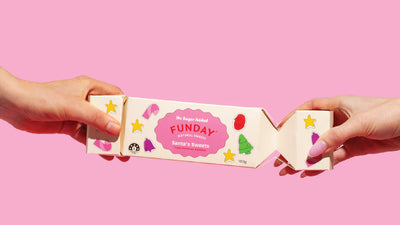 Two hands holding a box labeled 'FUNDAY' against a pink background